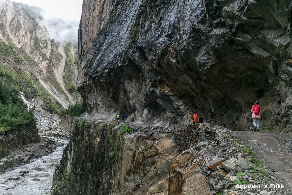 Trekkers walking toward Manang Valley along a Himalayan mountain trail in Nepal