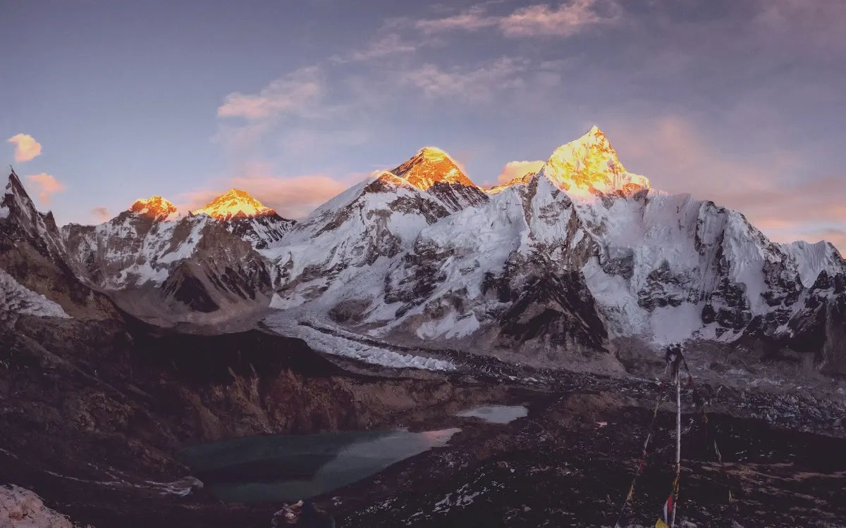 Mount Everest glowing in golden sunset light above the Himalayan mountains of Nepal.