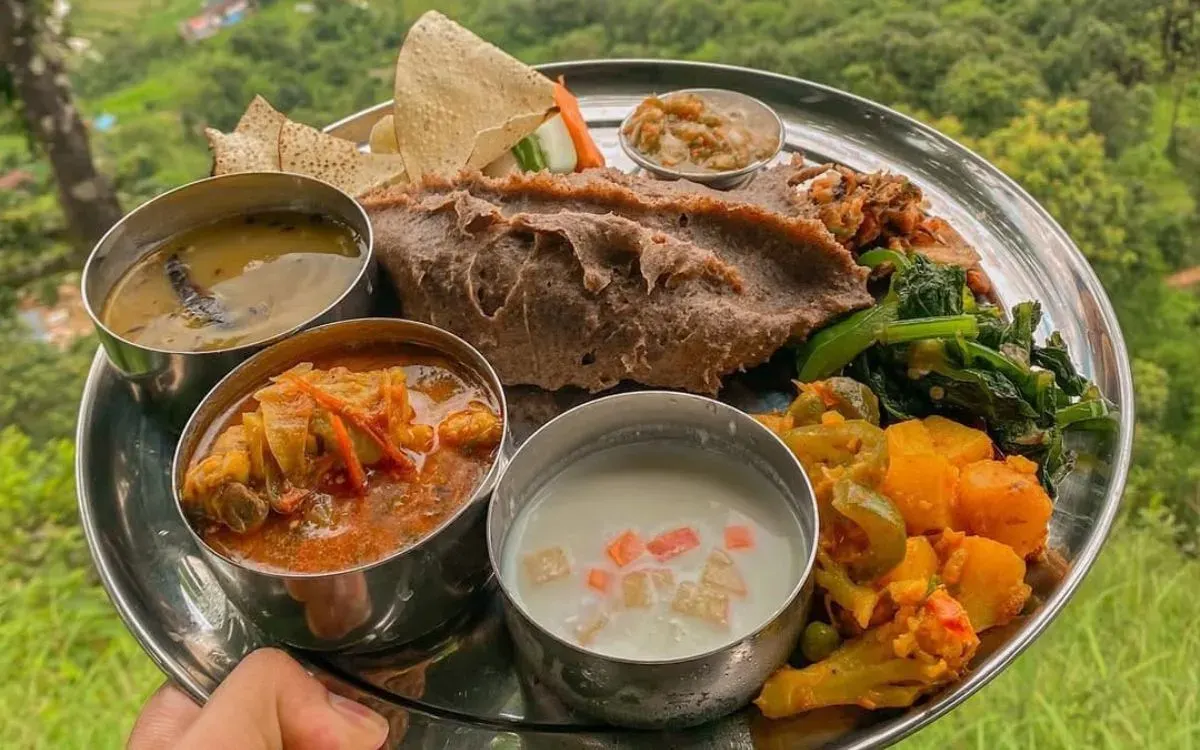 Traditional Nepali dhido made from millet or buckwheat flour, served with lentil soup, vegetable curry, greens, and local pickles.
