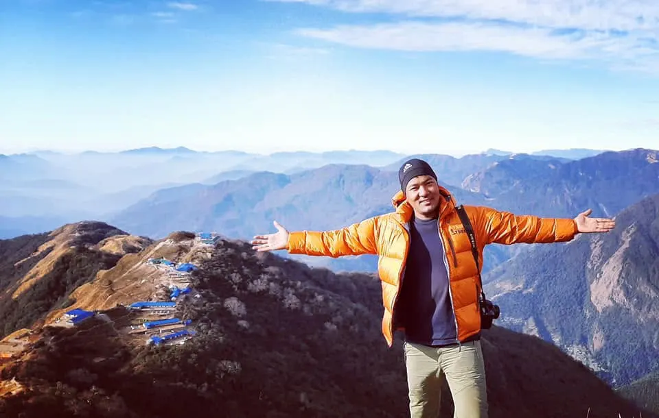 Trekkers on the Mardi Himal trail with dramatic high Himalayan peaks rising in the background.